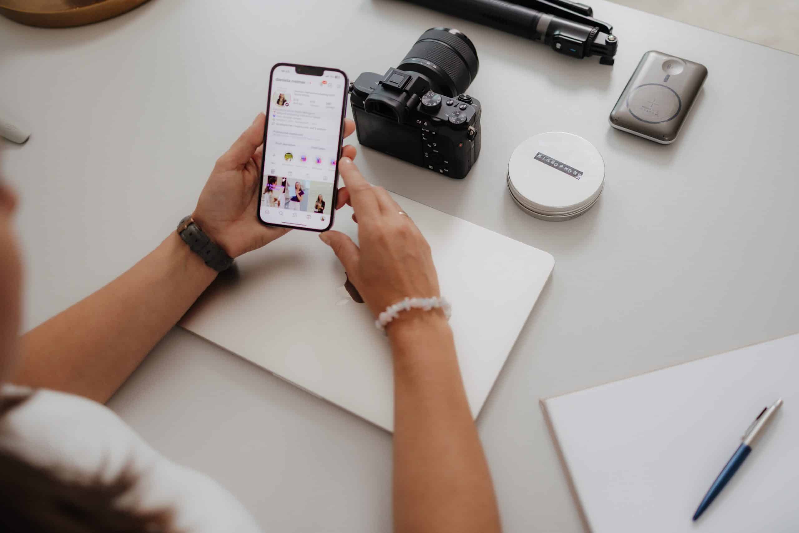 Foto &uuml;ber Danielas Schulter, die auf ihrem Handy Instagram offen hat