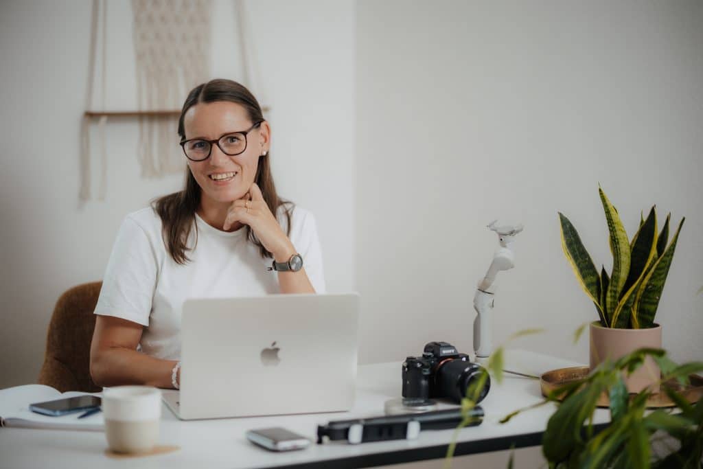 Daniela Neimer sitzt am Schreibtisch und ihr Laptop ist offen