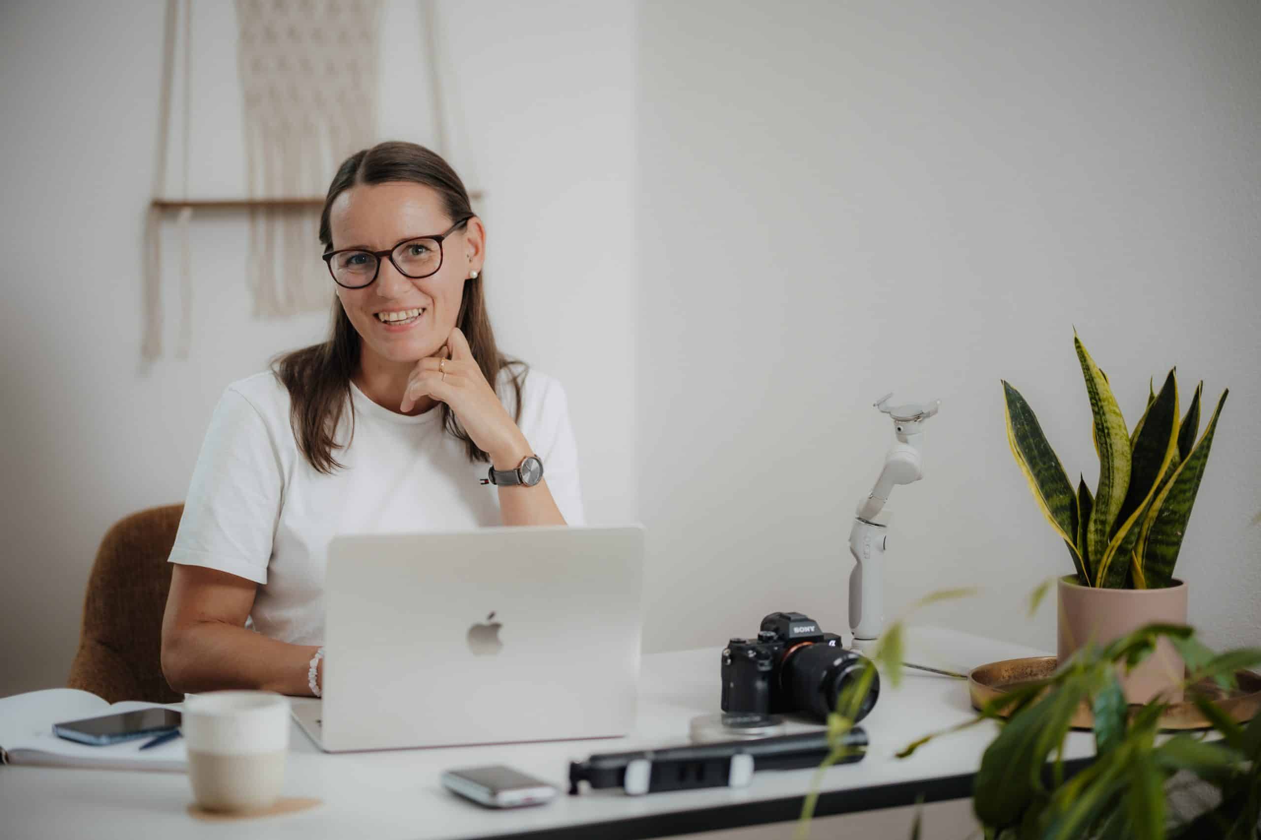 Daniela Neimer sitzt am Schreibtisch und ihr Laptop ist offen