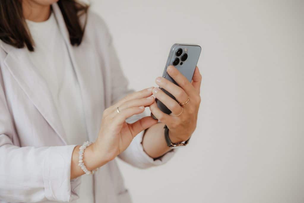 Daniela Neimer hat ihr Handy in der Hand und tippt darauf.